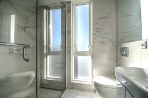 A bathroom with a glass shower enclosure, a toilet, and a sink. - Midtown Reykjavik - Standard Double or Twin Room (Reykjavík)