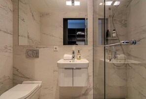 Un bagno moderno con il water, un lavandino e una doccia.