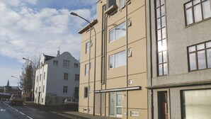 A multi-story residential building with a beige facade, large windows, and a visible garage door. - Saga Studio for 2 guests in Downtown Snorri (Reykjavík)