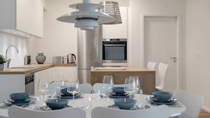 A modern kitchen with a built-in oven and a dining area with a table set for four.