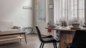 Ein moderner Essbereich mit Holztisch, schwarzen Stühlen und einem weißen Sofa.