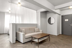 A modern living room with a sofa, a coffee table, and a door.