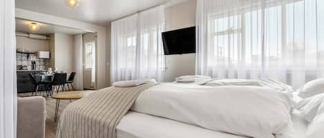 A hotel room with a bed, a desk, and a chair.