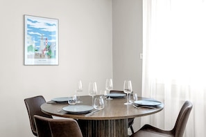 A dining area with a round table, four chairs, and a framed picture on the wall. - Swan Superior Studio Main Center (Reykjavík)