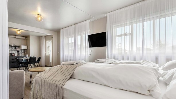A hotel room with a bed, a desk, and a chair.