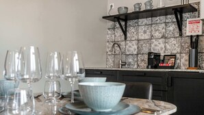 A kitchen with a tiled backsplash, a coffee machine, and a sign on the wall.