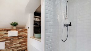 A bathroom with a toilet, a shower, and a wooden wall with a shelf.