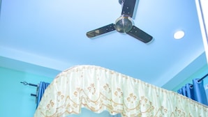 A room with a bed, a ceiling fan, and curtains. - DOM PRECIOUS LODGE (Dodoma)