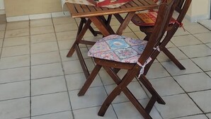 Ein Essbereich mit Holztisch und -stühlen, einer gepolsterten Bank und einem Fliesenboden.