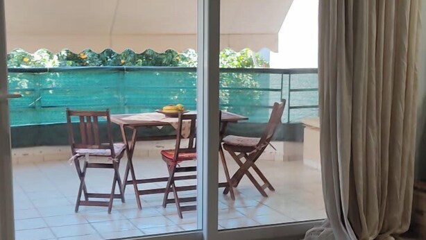 Ein Zimmer mit einer großen Schiebeglastür, die zu einem Außenbereich mit Pool und Esstisch führt.