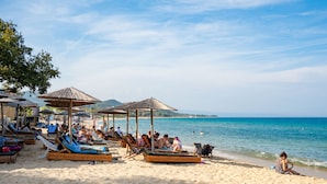 A beach with sun loungers and umbrellas, a clear sky, and the ocean in the background. - Aristi Villa Dio in Olimpiada (Aristotelis)