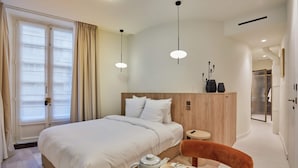 A hotel room with a bed, breakfast tray, and a wooden headboard. - Studio Louvre Museum Palais-royal (Paris)
