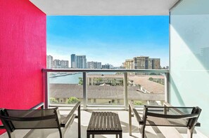A balcony with a city view, two chairs, and a table. - Waterfront Pool • Beach Service • 7th Floor (Hallandale Beach)
