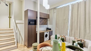Un appartement moderne comprenant une cuisine, un coin repas et un salon.