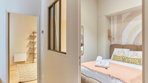 Une chambre à coucher avec un lit, des oreillers, une table de chevet et une fenêtre.
