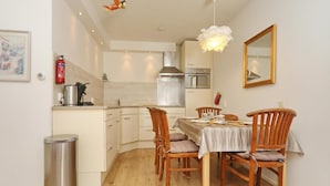 Cocina compacta con comedor, equipada con estufa, horno y lavaplatos.