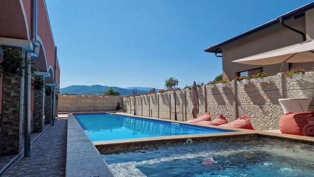 A swimming pool with a stone wall and a view of mountains in the background.