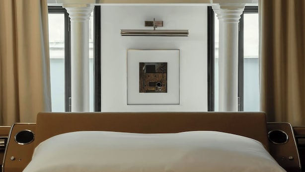 A hotel room with a bed, a framed picture on the wall, and a window with curtains. - Sublim and Design Apartement Place Vendome (Paris)