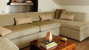 A modern living room with a sectional sofa, a wooden coffee table, and built-in shelves. - Sublim and Design Apartement Place Vendome (Paris)