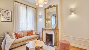 Una sala de estar con sofá, chimenea y una mesa de centro redonda.