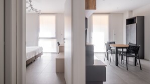 Una habitación moderna y bien iluminada con cama, escritorio y comedor.