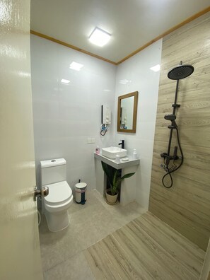 A small bathroom with a toilet, sink, and shower. - Maavaharu K.Himmafushi  (Himmafushi)