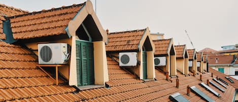 A row of buildings with sloped roofs and multiple air conditioning units installed.