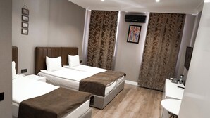 Une chambre d’hôtel avec deux lits, un petit bureau, une chaise et une salle de bain.