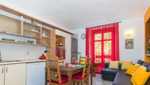 Een ruimtelijke leefruimte met een eethoek, keuken en zithoek.