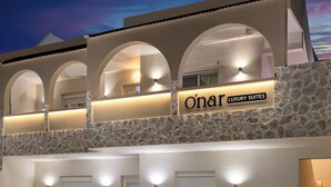 A hotel with a stone facade and arched windows, labeled "Oñar Luxury Suites".