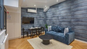 A modern living room with a sofa, a coffee table, and a dining area with chairs and a table. - Superb & New Apartment Saint Germain des Pres (Paris)