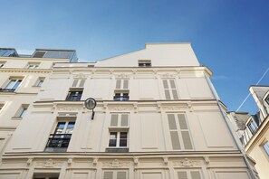 A multi-story building with classical architectural features, including decorative moldings and shutters. - Charming Apartment Center of Paris (Paris)