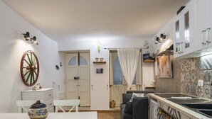Una cocina compacta con zona de comedor, un reloj y una rueda decorativa en la pared.
