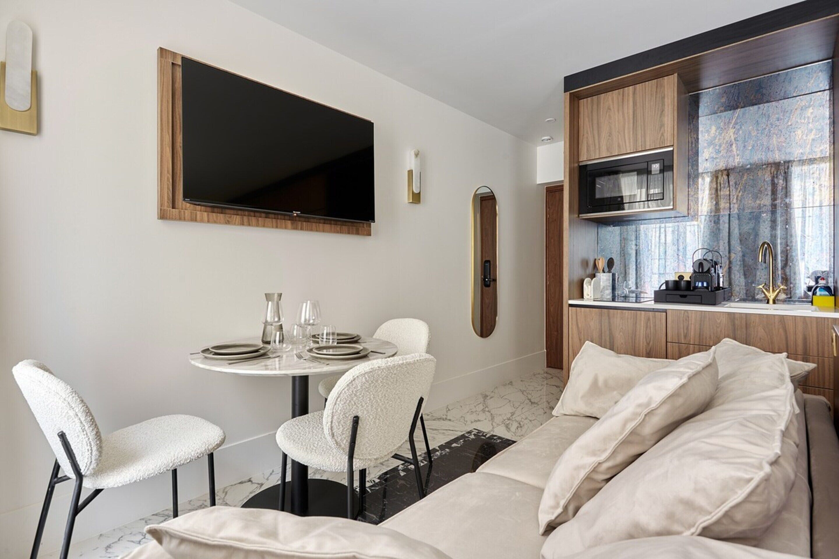 A compact living space with a dining area, kitchenette, and a bed.