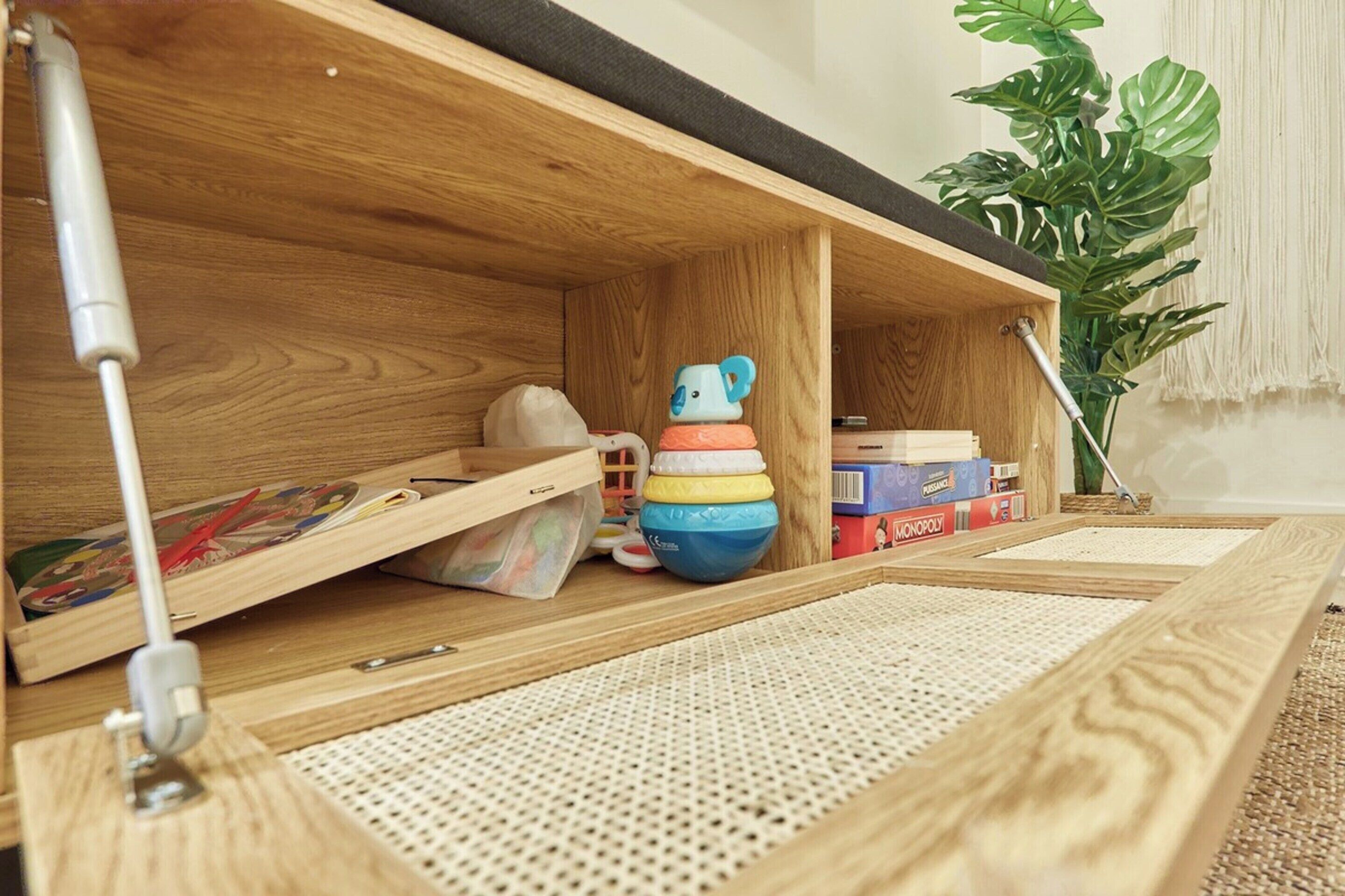 Un estante de madera con un juguete pequeño y juegos de mesa.