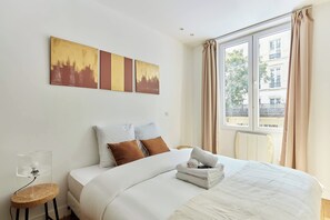 Laptop workspace, iron/ironing board, bed sheets - Charming Flat in the Heart of Paris (Paris)