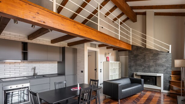 Una cocina moderna con comedor, chimenea y espacio en lo alto.