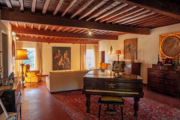 A spacious room with a grand piano, a sofa, and a wooden ceiling. - VILLA PARADISO, stunning XVII century villa on the hills at 7 kms east of Lucca (Capannori)