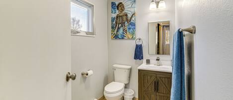 Une salle de bain avec des toilettes, un lavabo et un meuble de rangement.