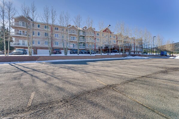 A multi-story residential building with a parking lot in front. - 1 Mi to Skiing: Mtn-view Condo in Angel Fire! (Angel Fire)