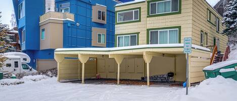 Un immeuble à plusieurs étages doté d’un parking couvert et d’un panneau indiquant les emplacements de stationnement en créneau.
