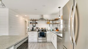 A modern kitchen with white cabinetry, a stainless steel oven, and a built-in dishwasher. - 1 Block to Beach: Home w/ Patio in Murrells Inlet! (Murrells Inlet)