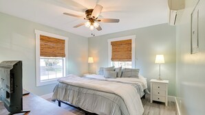 A bedroom with two beds, a ceiling fan, a TV, and a bedside table with a lamp. - 1 Block to Beach: Home w/ Patio in Murrells Inlet! (Murrells Inlet)