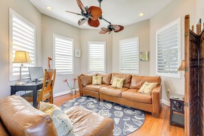A living room with a brown leather sofa, a round rug, and a ceiling fan. - Dock, Kayaks & On-site Pond: Terra Ceia Home (Palmetto)