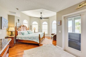 A bedroom with a large bed, a ceiling fan, and a view of the outdoors through a sliding door. - Dock, Kayaks & On-site Pond: Terra Ceia Home (Palmetto)
