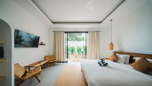 A hotel room with a bed, a TV, a desk, and a view of the outdoors. - 2BR Villa Seminyak with Pool (Seminyak, Badung Regency)