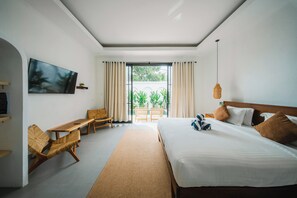 A hotel room with a bed, a TV, a desk, and a view of the outdoors. - 2BR Villa Seminyak with Pool (Seminyak, Badung Regency)