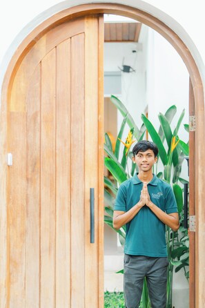 A person standing in front of a wooden door with a plant in the background. - 2BR Villa Seminyak with Pool (Seminyak, Badung Regency)