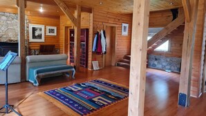 A log cabin interior with a sofa, a rug, and a staircase. - La Bella Patagonia (Cisnes)