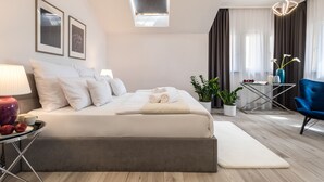 Un dormitorio moderno con una cama grande, mesitas de noche, un escritorio y una silla.